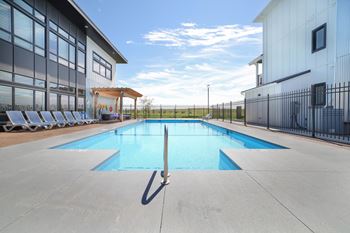 the pool area of a building with chairs around it